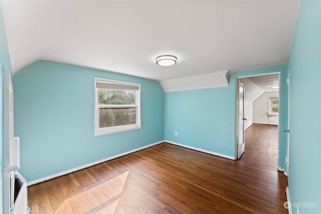 additional living space with dark hardwood / wood-style floors and vaulted ceiling