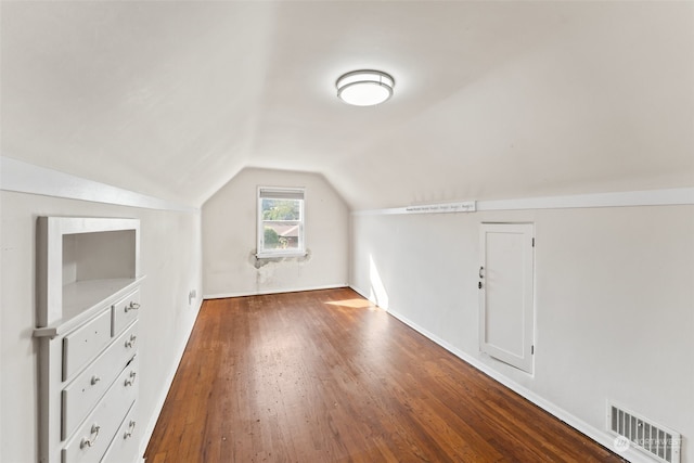 additional living space featuring lofted ceiling and dark hardwood / wood-style flooring