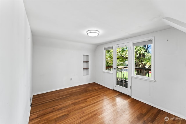 empty room with lofted ceiling and hardwood / wood-style floors