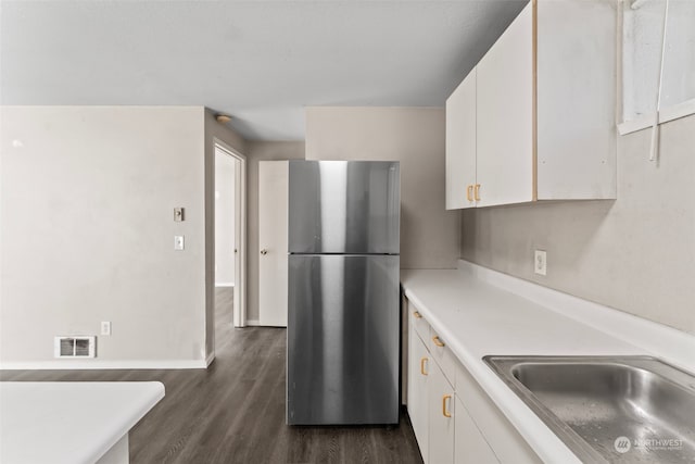 kitchen featuring stainless steel refrigerator, sink, dark wood-type flooring, and white cabinets