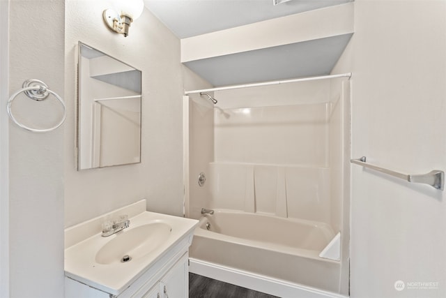 bathroom with hardwood / wood-style floors, shower / bathtub combination, and vanity