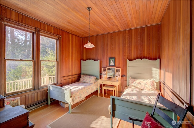 bedroom with wood ceiling, wooden walls, and light hardwood / wood-style flooring