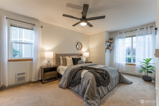 carpeted bedroom with heating unit and ceiling fan