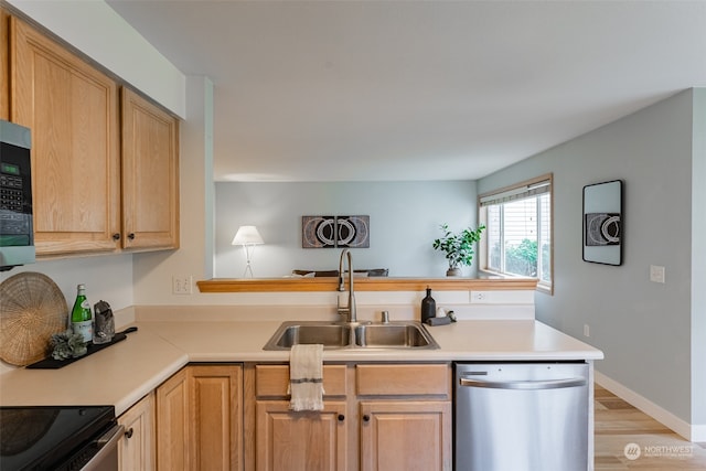 kitchen featuring kitchen peninsula, light wood-type flooring, stainless steel appliances, sink, and light brown cabinets