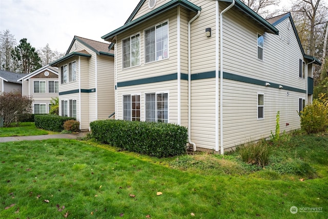 view of property exterior with a lawn