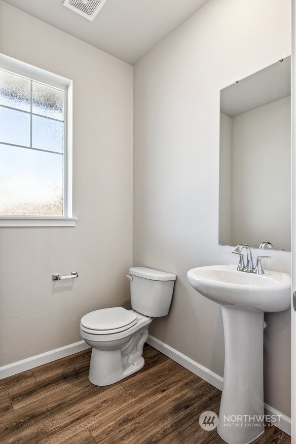 bathroom featuring wood-type flooring, toilet, and sink