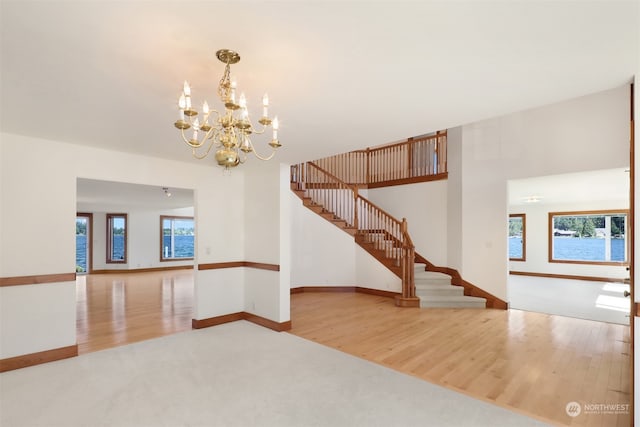 unfurnished room with hardwood / wood-style floors and a notable chandelier