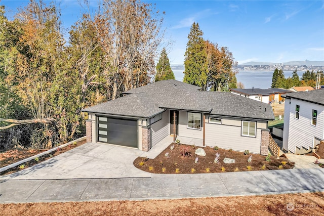 view of front facade featuring a water and mountain view and a garage