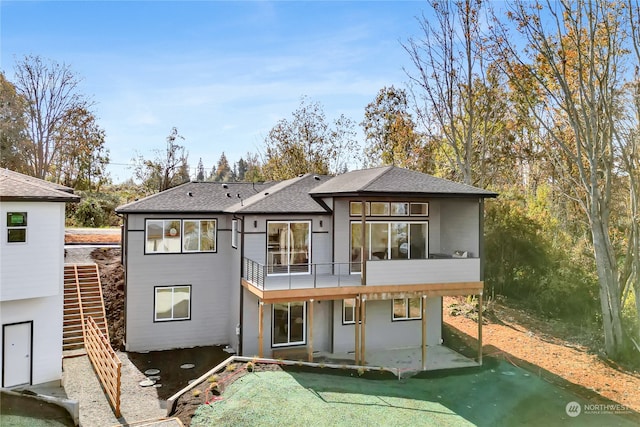 rear view of house with a balcony and a patio