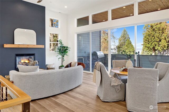 living room with a high ceiling, ceiling fan, and hardwood / wood-style flooring