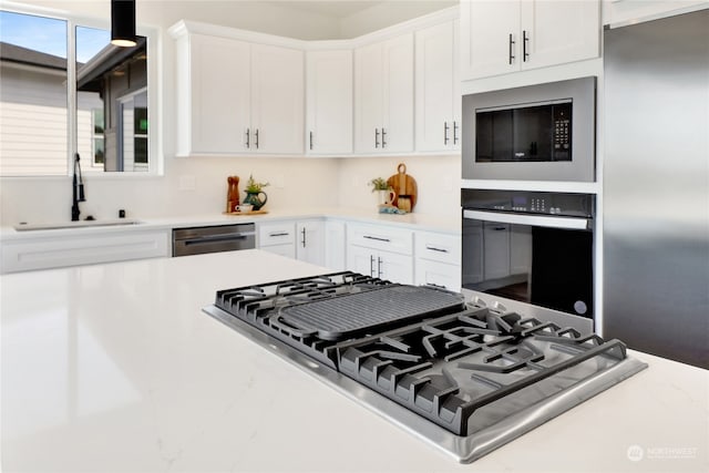 kitchen featuring stainless steel appliances, white cabinets, and sink