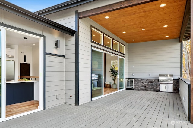 wooden deck with area for grilling and a grill