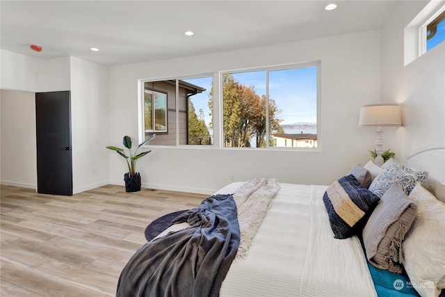 bedroom featuring light hardwood / wood-style flooring and multiple windows