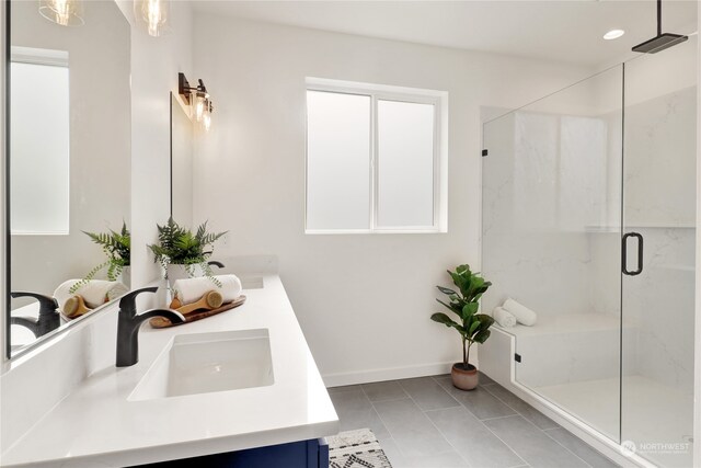 bathroom featuring tile patterned flooring, a shower with door, and vanity