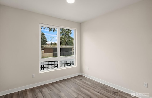 unfurnished room featuring baseboards and wood finished floors