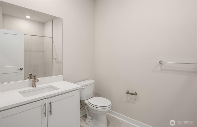 bathroom with vanity, toilet, and baseboards