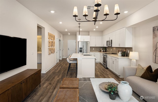 kitchen featuring white cabinetry, sink, hanging light fixtures, a kitchen island with sink, and stainless steel appliances