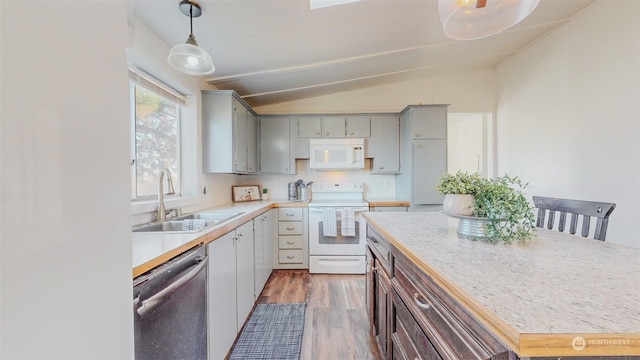 kitchen with light countertops, vaulted ceiling, a sink, white appliances, and dark wood-style flooring