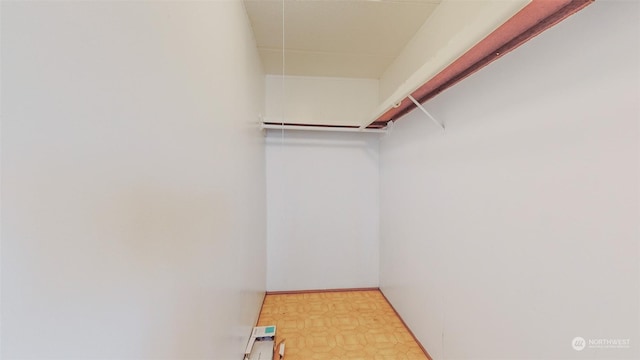 walk in closet with light floors