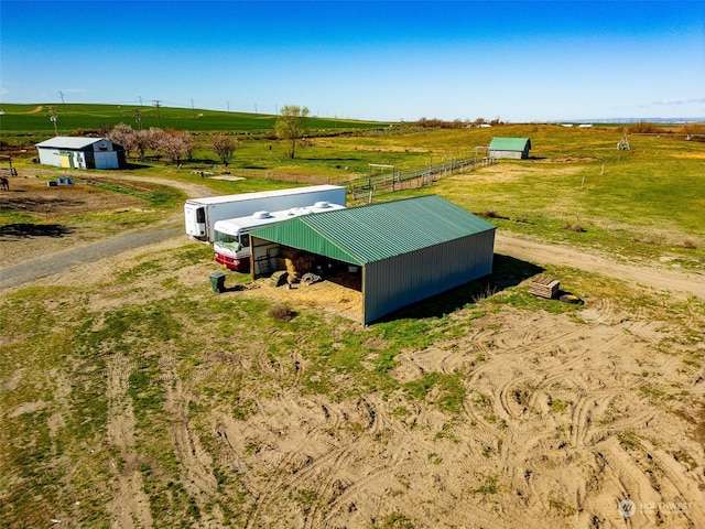 entry to storm shelter with a rural view, an outbuilding, and a pole building