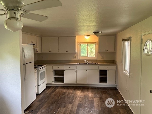 kitchen with white cabinets, dark wood-type flooring, and white appliances