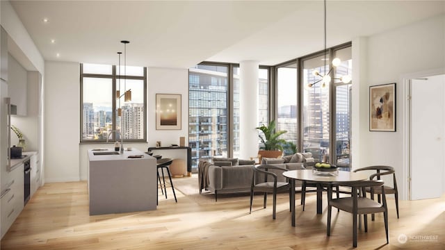 dining space featuring sink, a notable chandelier, light wood-type flooring, and a wall of windows