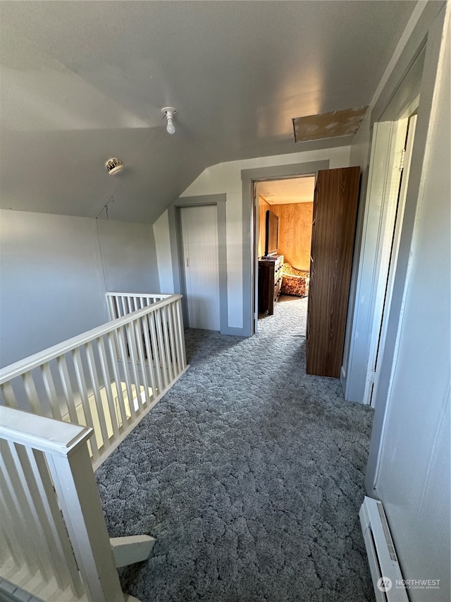 hallway with carpet, baseboard heating, and vaulted ceiling