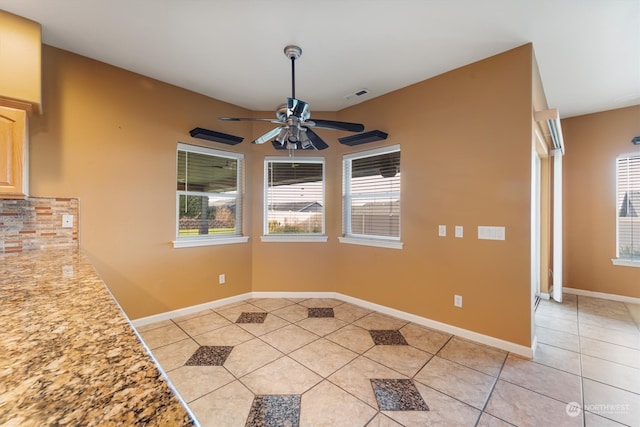 unfurnished dining area featuring light tile patterned floors and ceiling fan