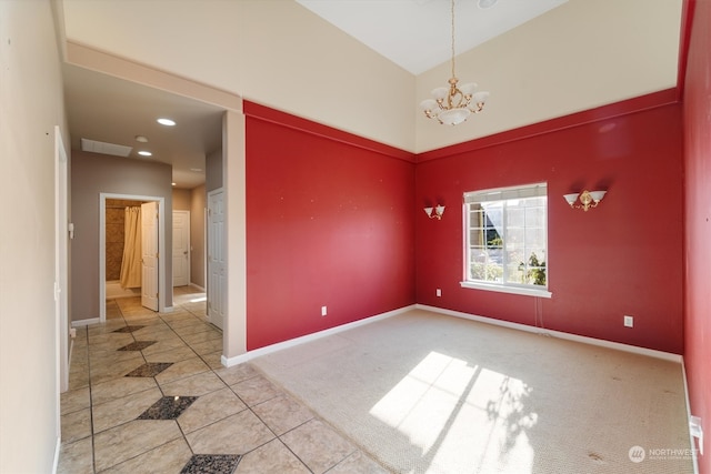 carpeted spare room featuring a notable chandelier