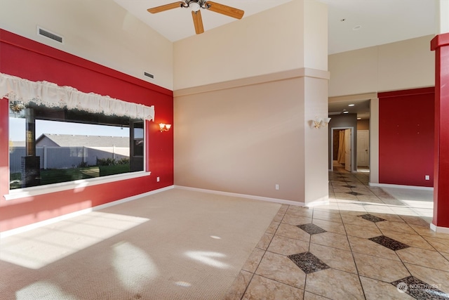 unfurnished room featuring ceiling fan, a high ceiling, and tile patterned floors