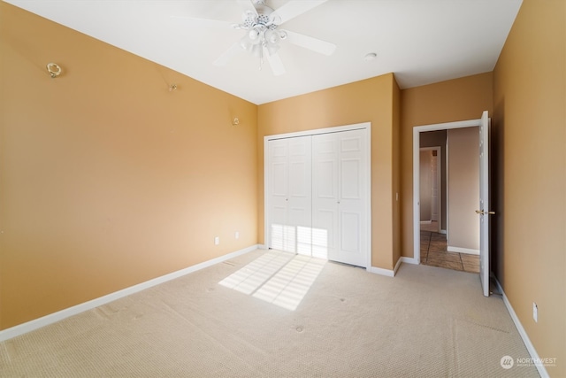 unfurnished bedroom with ceiling fan, light colored carpet, and a closet