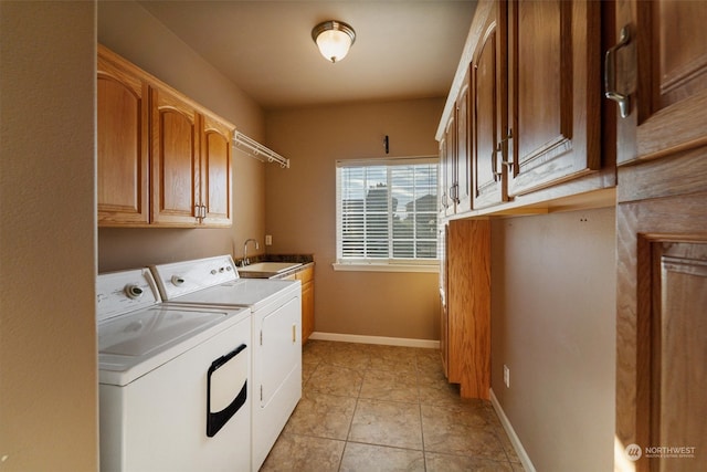 laundry area featuring washer and clothes dryer, sink, light tile patterned floors, and cabinets