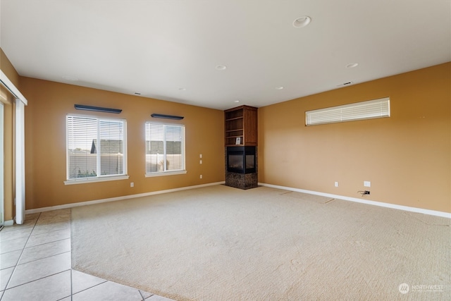 unfurnished living room with light tile patterned flooring and a multi sided fireplace