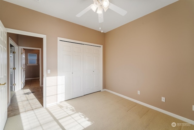 unfurnished bedroom with ceiling fan, light colored carpet, and a closet