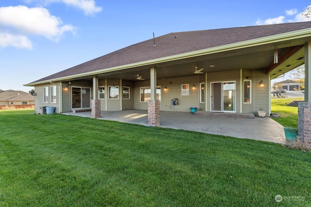 rear view of property featuring a lawn and a patio