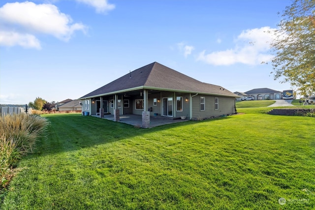 back of property with a yard and a patio area