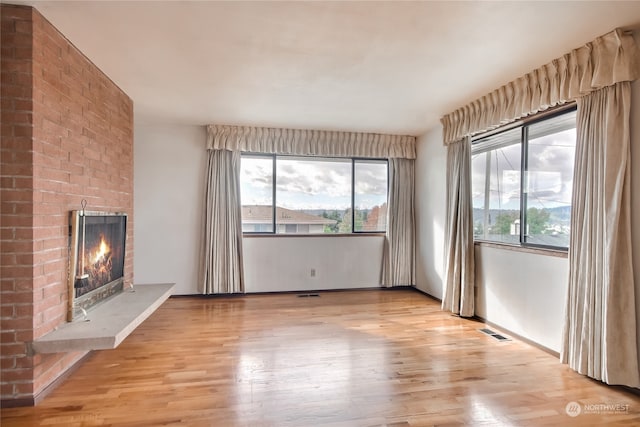 unfurnished living room featuring light hardwood / wood-style flooring and a fireplace