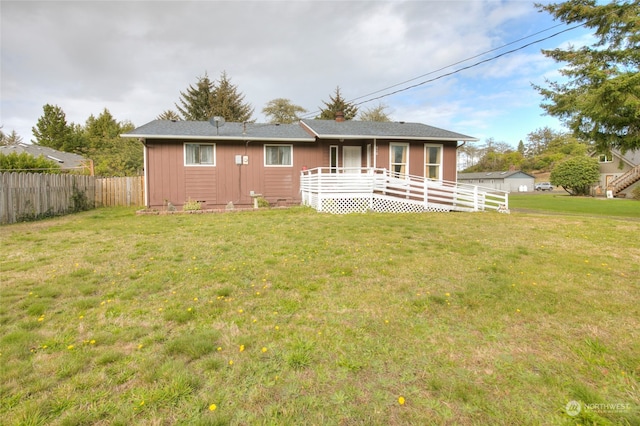 rear view of house with a lawn and a wooden deck