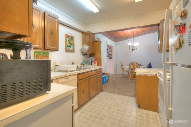 kitchen featuring pendant lighting, a chandelier, vaulted ceiling, light colored carpet, and white appliances