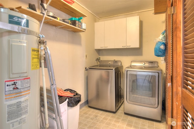 laundry room with water heater, washer and clothes dryer, and cabinets