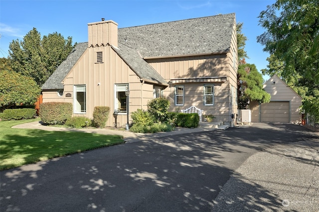 view of front of home featuring a front lawn, an outdoor structure, and a garage