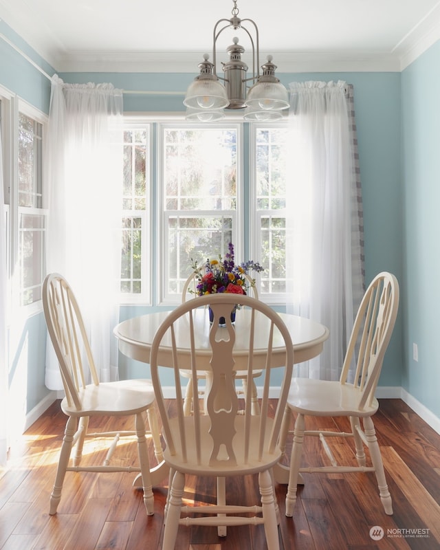 dining space with a notable chandelier, hardwood / wood-style flooring, and ornamental molding