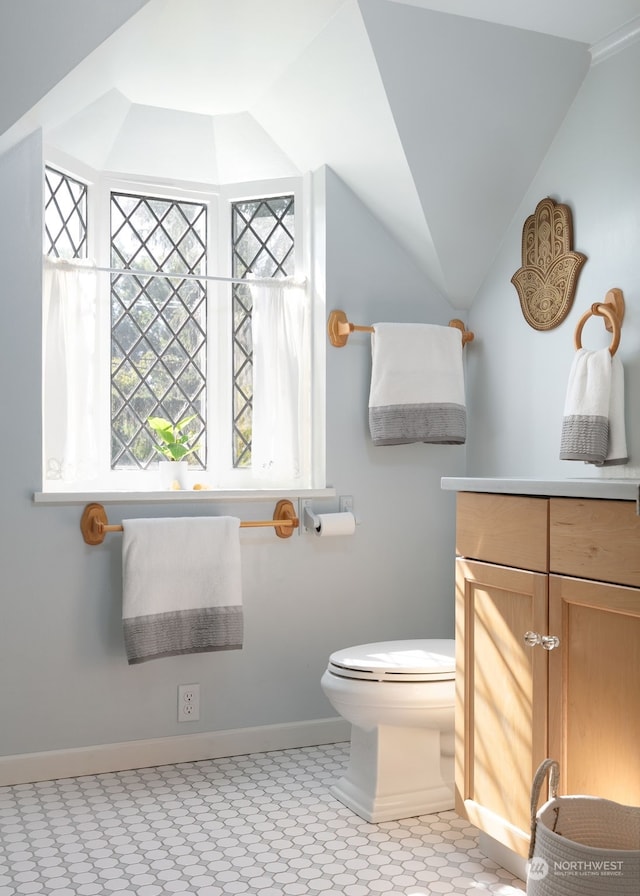 bathroom with vanity, lofted ceiling, and toilet