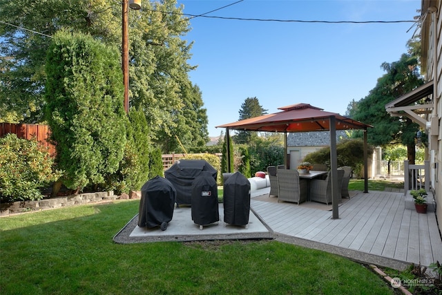 deck featuring grilling area, a gazebo, and a lawn