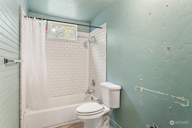 bathroom featuring shower / tub combo and toilet