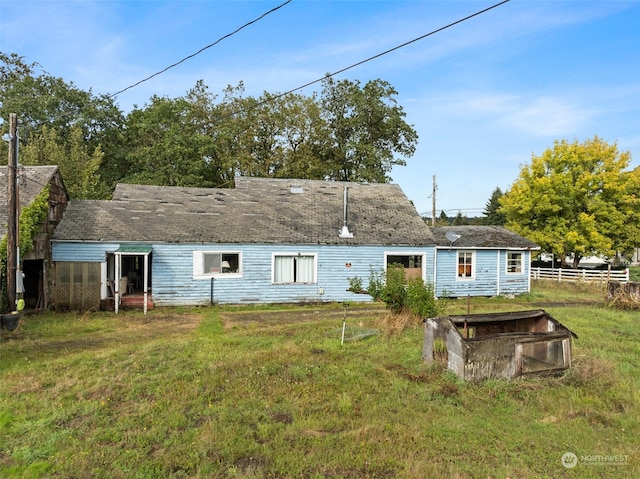 rear view of house featuring a lawn