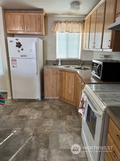 1257 Arkansas Dr, Walla Walla, WA 99362 - kitchen with white appliances, under cabinet range hood, a sink, stone finish floors, and brown cabinetry