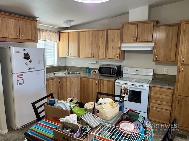 kitchen featuring white appliances, vaulted ceiling, and sink