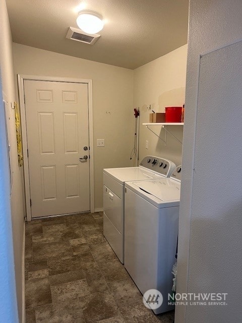 washroom with a textured ceiling and washing machine and dryer