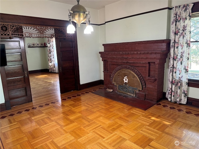 unfurnished living room featuring a brick fireplace and light parquet flooring